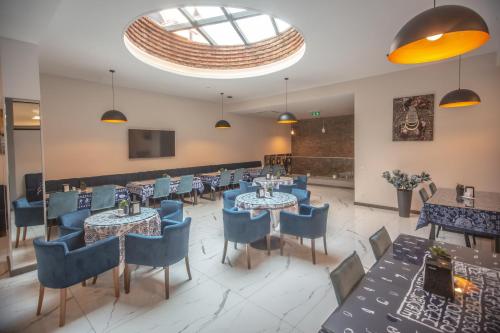 a restaurant with tables and chairs and a large window at Hotel Banovani in Tbilisi City