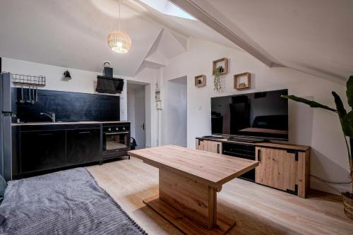 ein Wohnzimmer mit einem Holztisch und einem großen TV in der Unterkunft Liberation - F2 apartment near Disneyland Paris in Montry