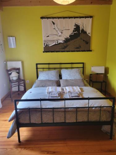 Cama en habitación con pared amarilla en chambre à la campagne Saint André de Chalencon, en Saint-André-de-Chalençon