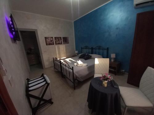 a bedroom with a bed and a table and chairs at B&B Villa Maracujà in Ionadi