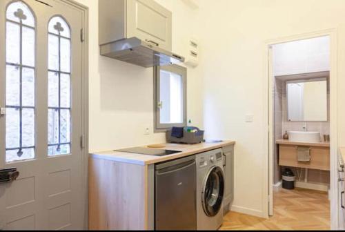 une cuisine avec une machine à laver et un évier dans l'établissement Le Coeur De Fontainebleau 1-Bedroom Retreat, à Fontainebleau