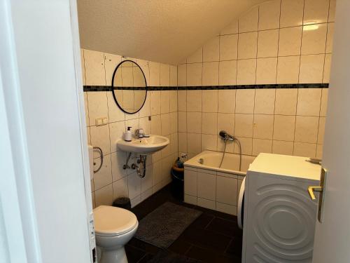 een badkamer met een toilet, een wastafel en een bad bij A&V Apartments Schöne Dachgeschoss Wohnung in Gelsenkirchen