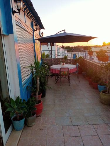 a patio with a table and an umbrella at Eden sidi bousaid in Dar Mimoun Bey