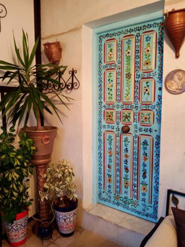 Dar Mimoun Bey的住宿－Eden sidi bousaid，一间种植了盆栽植物的房间的蓝色门