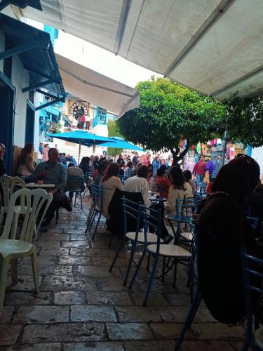 un grupo de personas sentadas en un restaurante al aire libre en Eden sidi bousaid, en Dar Mimoun Bey