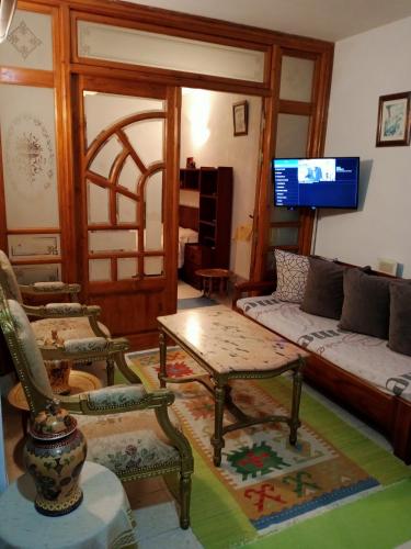 a living room with a couch and chairs and a tv at Eden sidi bousaid in Dar Mimoun Bey