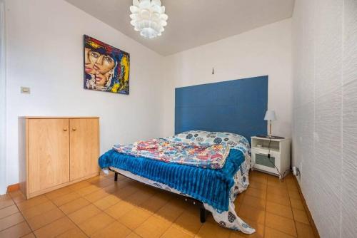 une chambre avec un lit et un tableau au mur dans l'établissement Bel appartement T2 climatisé entre mer et calanque, à Marseille