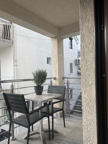 a table and chairs on a balcony with a potted plant at Apartments Villa Stefan in Budva