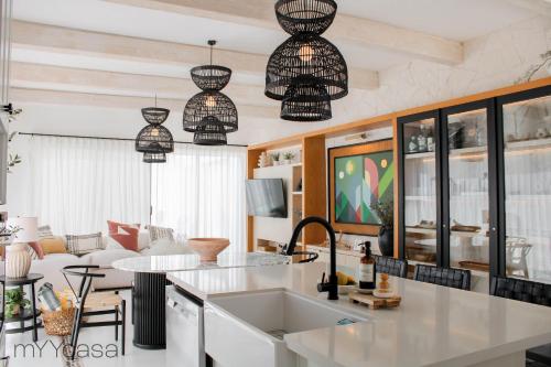 a kitchen and living room with pendant lights at House with Pool in Sector Bahia, Close to the Beach - Casa Amalia in San Carlos