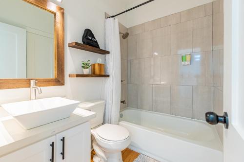 ein Badezimmer mit Waschbecken, Toilette und Badewanne in der Unterkunft Casa de Luz and The PoolClub at Mahogany Bay! in San Pedro