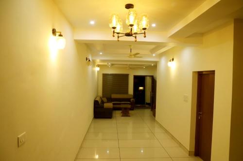 a hallway leading to a living room with a chandelier at Clover Home in Thiruvalla