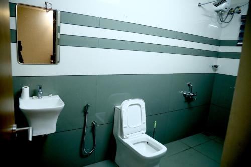 a bathroom with a toilet and a sink at Clover Home in Thiruvalla