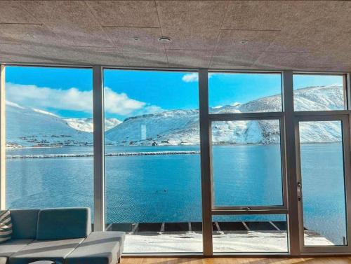 a room with a large window looking out at snow covered mountains at Pauli’s Boathouse in Vestmanna