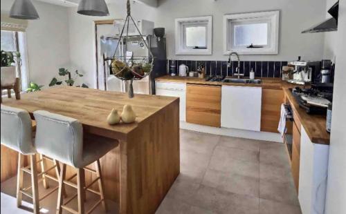 a kitchen with a large wooden island in a kitchen at Wild Pines Waterfront Guesthouse BBQ Pet Friendly in Jindabyne