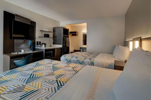 a hotel room with two beds and a desk at Studio 6 Grand Junction, CO in Grand Junction