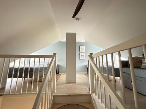 Una escalera que conduce a un dormitorio con cama en New Åkrahamn coast house, en Sæveland