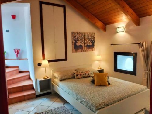 1 dormitorio con 1 cama con 2 lámparas y escaleras en NEL CUORE DI VIETRI CASA VACANZE AMALFI COAST, en Vietri