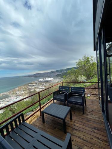 three benches on a deck with a view of the ocean at Trabzon Silent Hill Bungalow in Trabzon