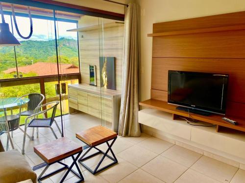 sala de estar con TV, mesa y sillas en Flat Paraíso em Serra Negra- Bezerros/PE en Bezerros