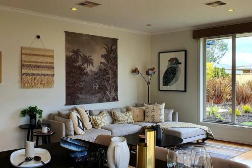a living room with a couch and a table at Luxurious beach stay, nearby famous wineries in Aldinga Beach