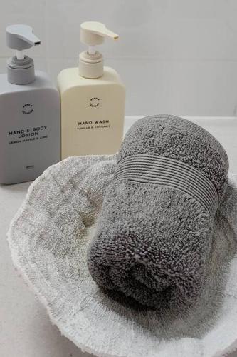 a towel and two bottles of soap on a counter at Luxurious beach stay, nearby famous wineries in Aldinga Beach