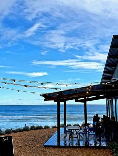 a group of people sitting under a pavilion at the beach at Luxurious beach stay, nearby famous wineries in Aldinga Beach