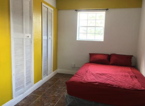 a bedroom with a red bed and a window at Miami House in Miami