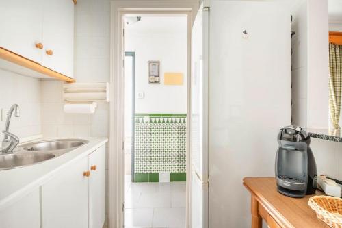 cocina blanca con lavabo y ducha en Preciosa casa independiente con increibles vistas, en Vejer de la Frontera