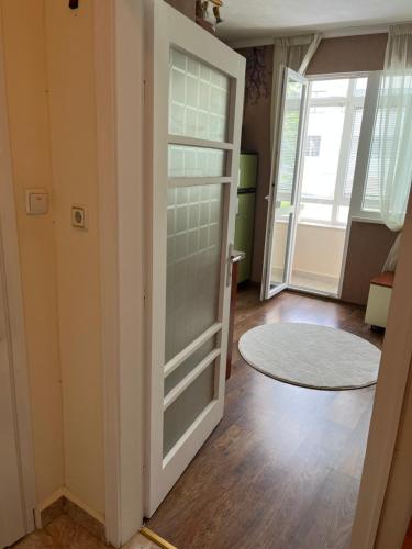 Habitación con puerta corredera de cristal y alfombra. en Apartment Acacia en Varna