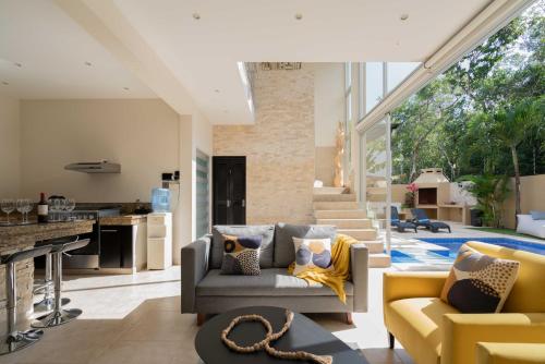a kitchen and living room with a couch and chairs at Tulum Private Modern Villa-Pool Beds-AC-Internet-Parking-Grill in Tulum