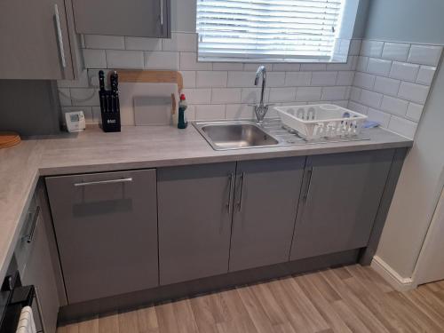 a kitchen with a sink and a counter top at Chorlton Apartments in Sale