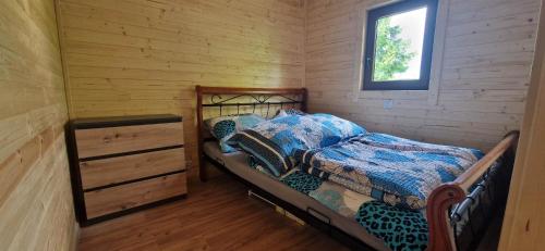 ein Schlafzimmer mit einem Bett und einer Kommode in einer Blockhütte in der Unterkunft Chatka pod orzechem in Spytkowice
