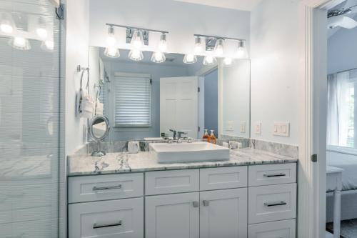 a white bathroom with a sink and a mirror at Tropical Retreat in Key West