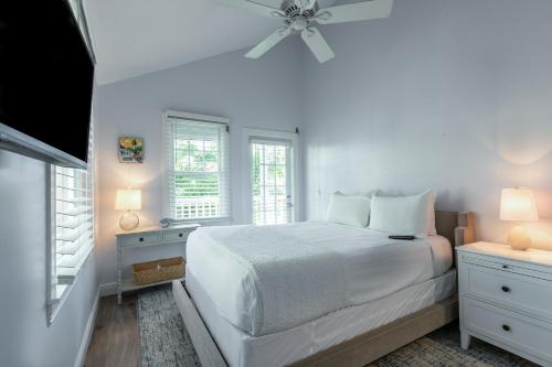 a white bedroom with a bed and a ceiling fan at Tropical Retreat in Key West