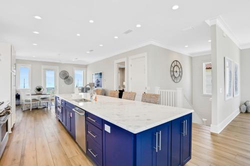 a kitchen with blue cabinets and a white counter top at Macon Memories in St. George Island