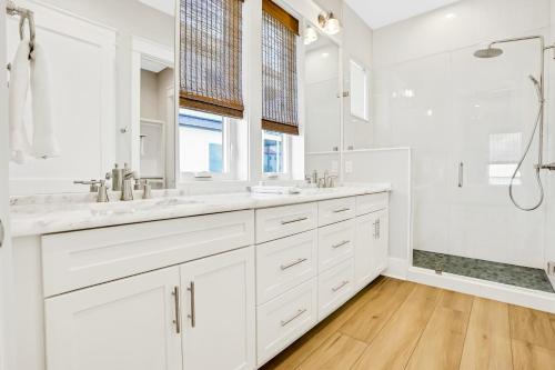 a white bathroom with two sinks and a shower at Macon Memories in St. George Island