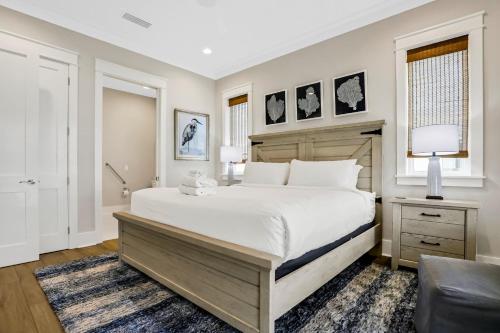 a bedroom with a large white bed and a chair at Macon Memories in St. George Island