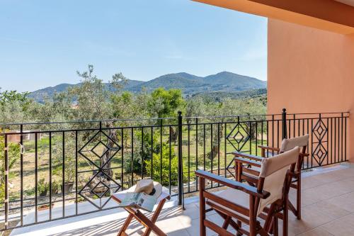 two chairs on a balcony with a view of mountains at Eleonora's in Skopelos Town