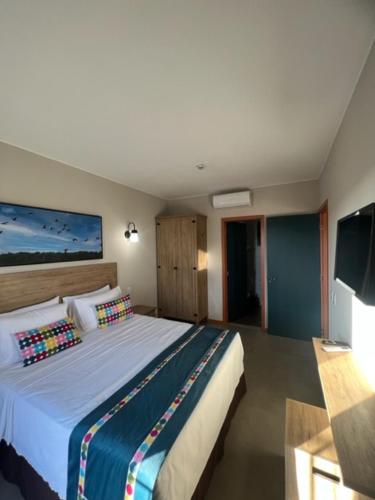 Resort Quinta Santa Bárbara في بيرينوبوليس: غرفة نوم بسرير كبير وتلفزيون بشاشة مسطحة