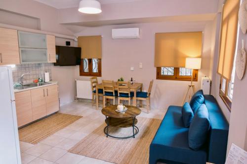 a living room and kitchen with a blue couch and a table at Morpheus Realm Apartment in Ioannina