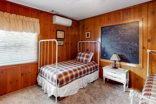 a bedroom with a bed and a chalkboard on the wall at Wilts Happy Place in Bass Lake