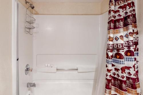 a bathroom with a shower with a christmas shower curtain at Wilts Happy Place in Bass Lake
