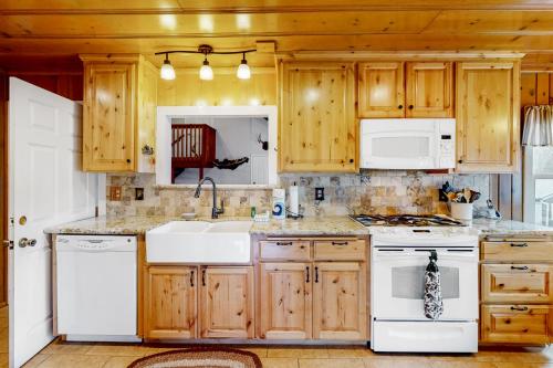 a kitchen with white appliances and wooden cabinets at Wilts Happy Place in Bass Lake