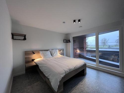 - une chambre avec un lit et une grande fenêtre dans l'établissement Bigaro II, à Heers