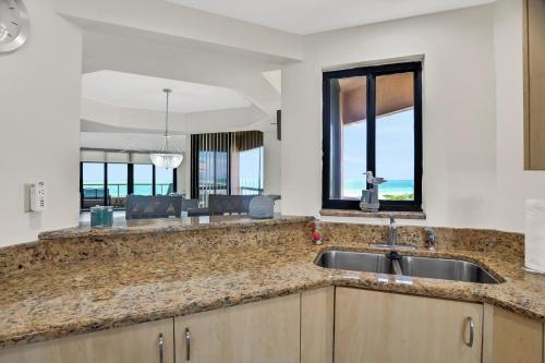 a kitchen with a sink and a large window at Crescent Beach Club I 4G in Clearwater Beach