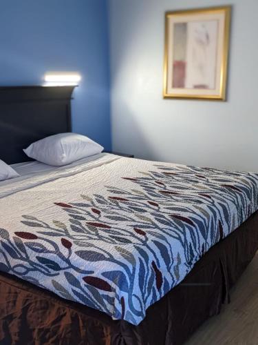 a bed with a colorful quilt on top of it at Budget Inn Alexandria in Alexandria