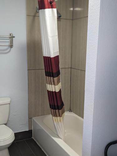 アレクサンドリアにあるBudget Inn Alexandriaのトイレの隣に赤と白のシャワーカーテンが付いたバスルームが備わります。