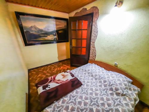 a bedroom with a bed and a painting on the wall at La Vitalie Guest House in Chişinău