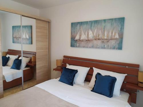 a bedroom with two beds with blue pillows at Apartments by the sea Businci, Ciovo - 4668 in Trogir
