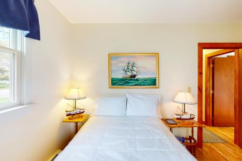 um quarto com uma grande cama branca e 2 candeeiros em Hyannis Beach House em Hyannis